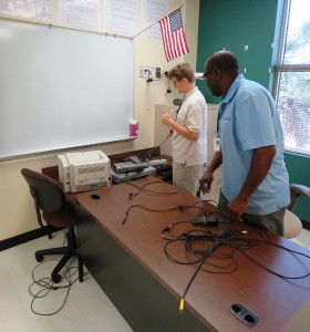 Derek Hastings, a rising senior at Wando HS, is assisting with the reconnection of hardware in classrooms at his school in preparation for the upcoming school year. 